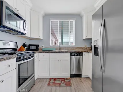 a kitchen with stainless steel appliances granite countertop a refrigerator sink and stove