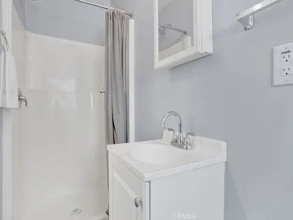 a bathroom with a sink a mirror and shower