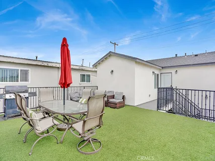 a view of a patio with table and chairs with wooden floor and fence