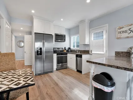 a kitchen with granite countertop stainless steel appliances a sink and a refrigerator