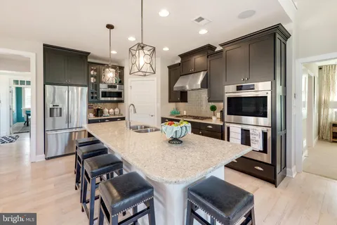 a kitchen with stainless steel appliances granite countertop a sink refrigerator and microwave