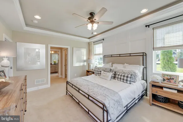 a bedroom with a large bed and a chandelier