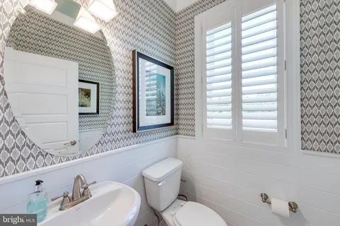 a bathroom with a toilet a sink and mirror