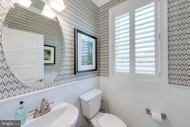 a bathroom with a toilet a sink and mirror