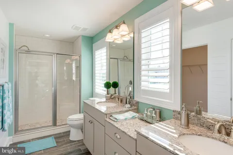 a bathroom with a granite countertop sink toilet and shower