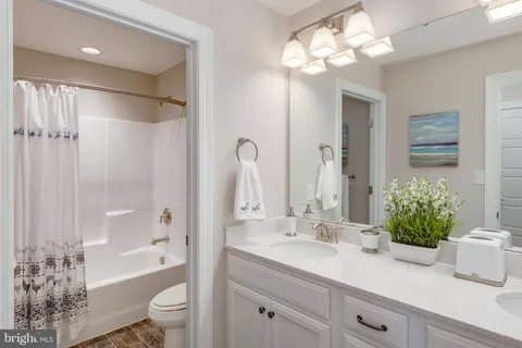 a bathroom with a granite countertop sink a toilet and shower