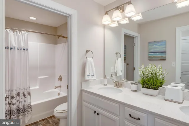 a bathroom with a granite countertop sink a toilet and shower