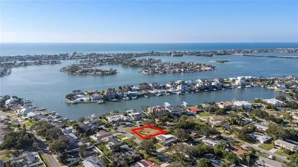 an aerial view of ocean and residential houses with outdoor space