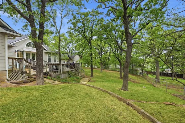 an aerial view of residential houses with outdoor space and trees