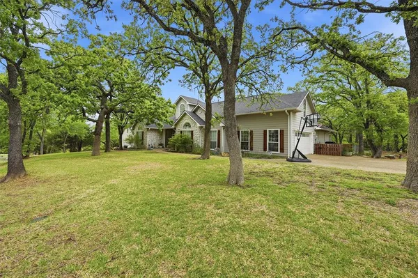 a view of a house with a tree and a yard