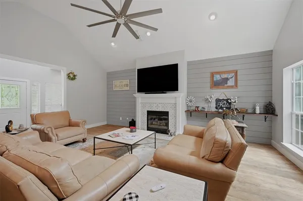 a living room with furniture a fireplace and a flat screen tv