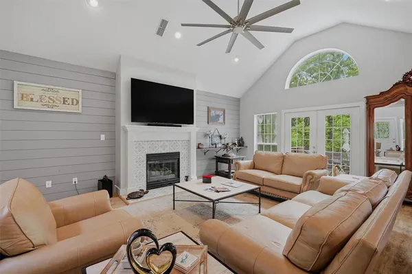a living room with furniture a fireplace and a flat screen tv