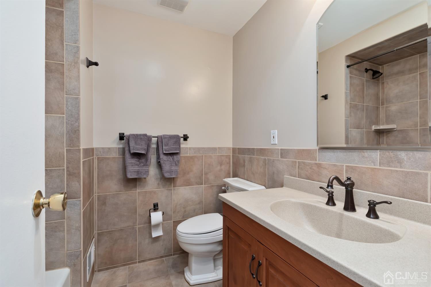 1 Greenwich Road Edison, NJ 08820 - Photo 22 of 26 a bathroom with a granite countertop sink a mirror and a toilet