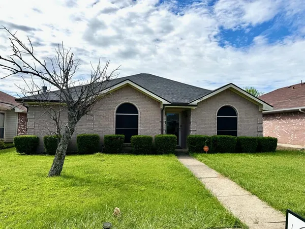 a front view of a house with a yard and trees