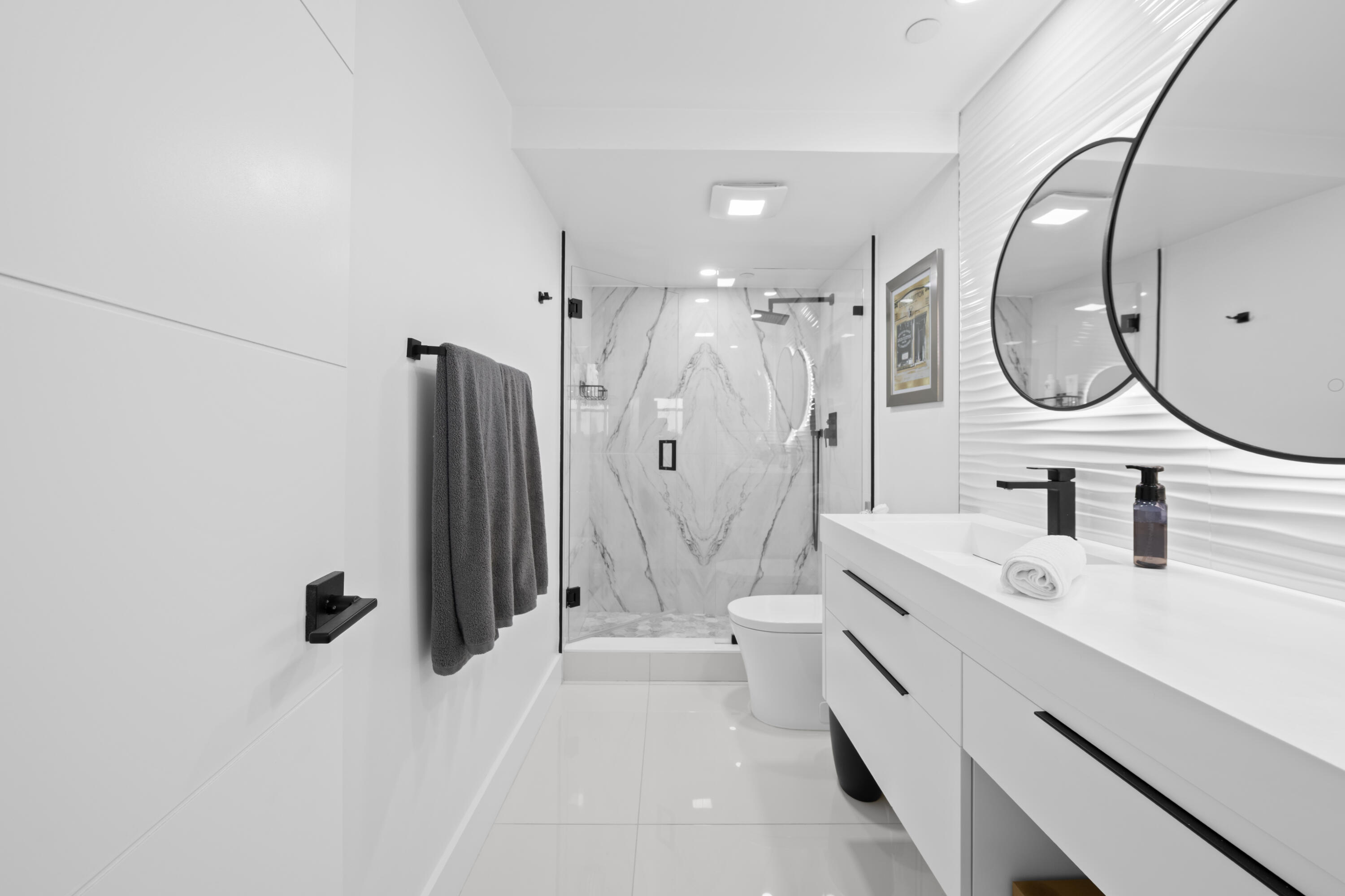 899 Jeffery Street, Unit 612 Boca Raton, FL 33487 - Photo 26 of 63 a spacious bathroom with a double vanity sink a mirror a bathtub and shower