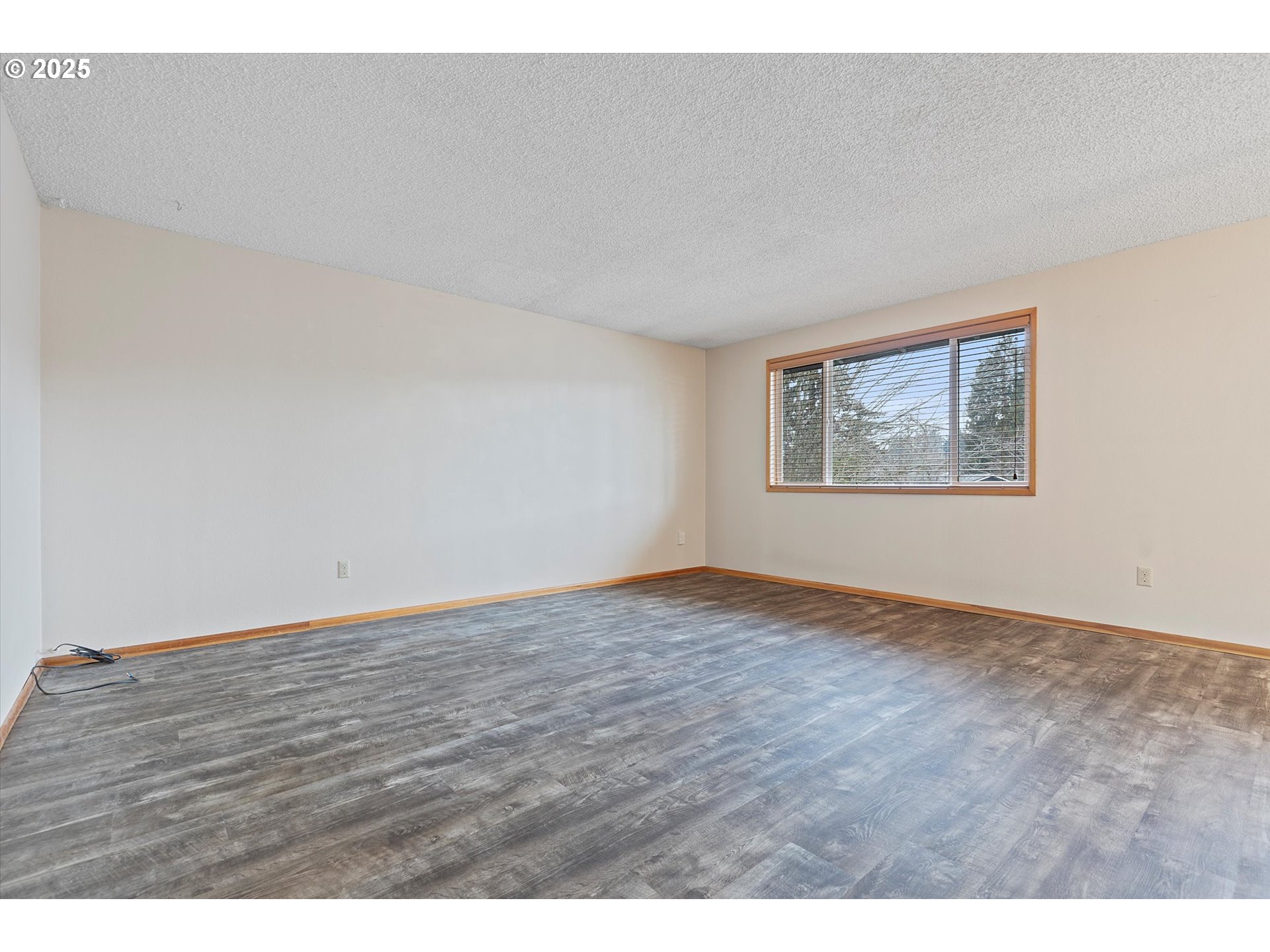 1295 Northwest Riverview Avenue Gresham, OR 97030 - Photo 6 of 35 a view of an empty room with wooden floor and a window