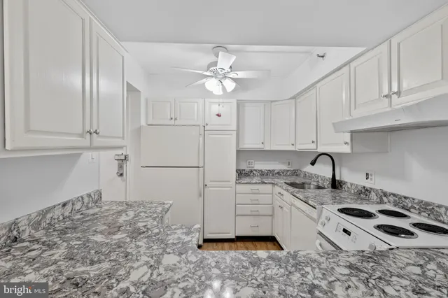 a kitchen with granite countertop a sink stainless steel appliances and cabinets