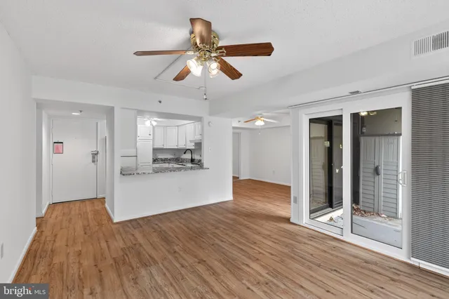 a view of a livingroom with wooden floor and a ceiling fan