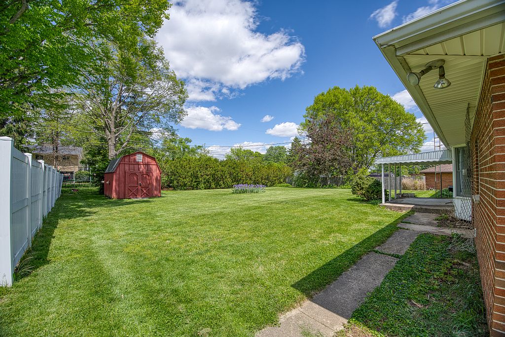 324 Beckenham Road Englewood, OH 45322 - Photo 24 of 26 Expansive green space offers a serene escape, complete with a charming red shed.