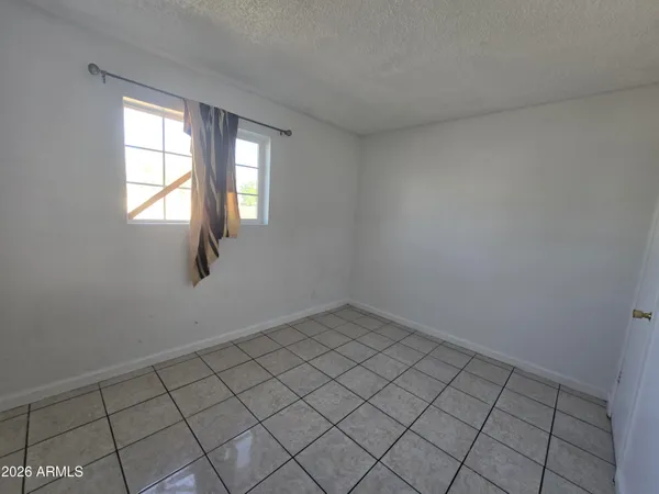 a view of an empty room with window and fire place