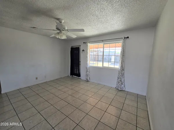 an empty room with windows and fan