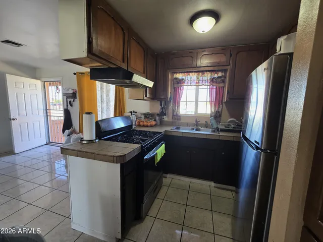 a kitchen with a stove a refrigerator and a sink