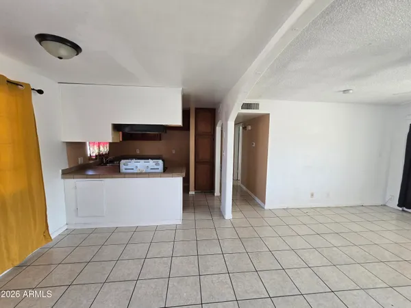a view of kitchen with cabinets and refrigerator