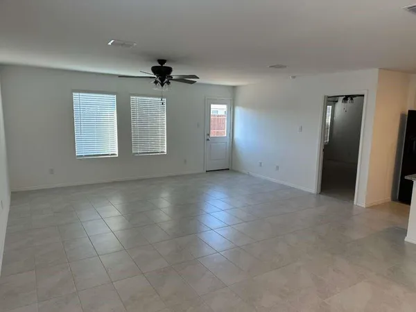an empty room with windows and fan