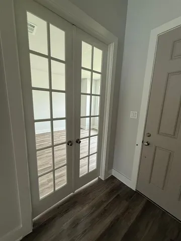 an empty room with wooden floor and windows