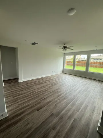 a view of a hallway with wooden floor and stairs