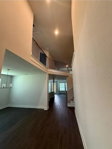 a view of a hallway with wooden floor and stairs