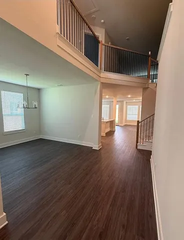 a view of a kitchen and an empty room with a window