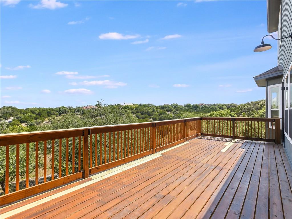 13301 Lone Rider Trail Bee Cave, TX 78738 - Photo 8 of 22 A spacious wooden deck provides ample outdoor living space with panoramic views of the verdant landscape.