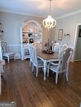 a dining room with furniture a chandelier and wooden floor