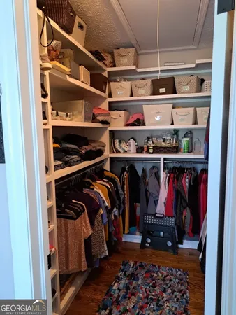 a view of walk in closet with clothes and shoes