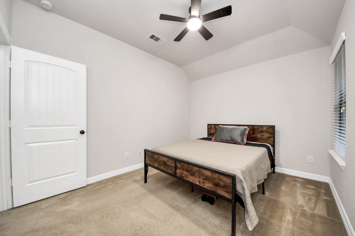 25122 Alina Lane Spring, TX 77386 - Photo 22 of 27 a bedroom with a bed and a chandelier