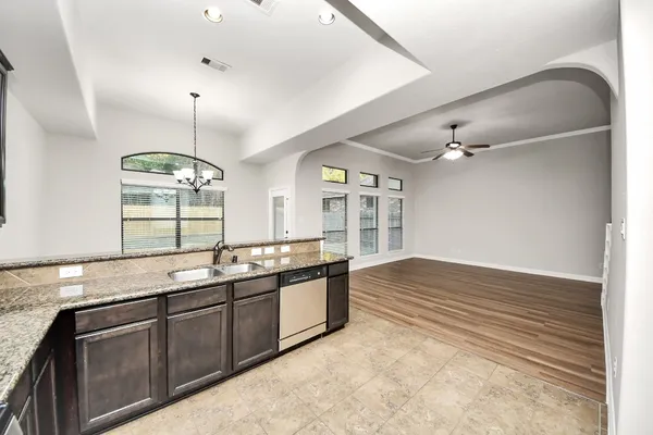 a kitchen with stainless steel appliances granite countertop a sink and dishwasher with wooden floor