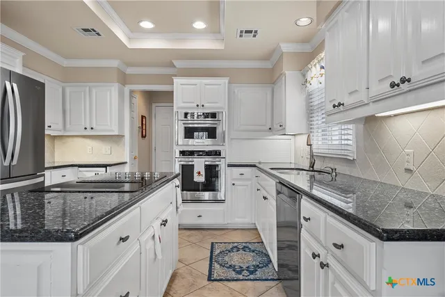 a kitchen with stainless steel appliances granite countertop a sink stove and cabinets