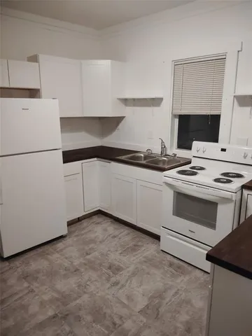 a kitchen with granite countertop a sink and a stove