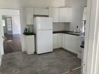 a kitchen with a refrigerator sink and cabinets