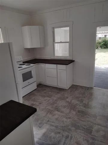a kitchen with granite countertop a stove a sink and a microwave