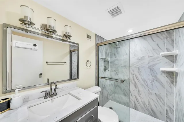 a bathroom with a sink toilet a mirror and shower