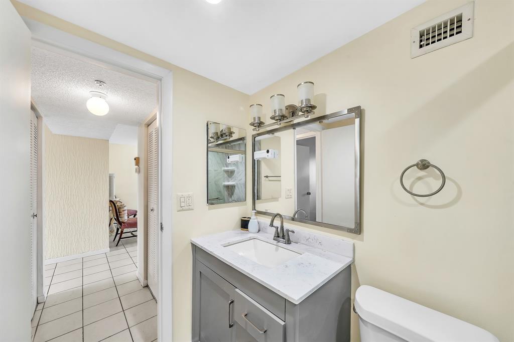 6200 Northwest 44th Street, Unit 405 Lauderhill, FL 33319 - Photo 18 of 44 a bathroom with a sink a toilet and a mirror