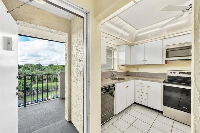 a kitchen with white cabinets and white appliances