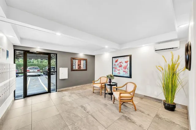a living room with patio furniture and a potted plant