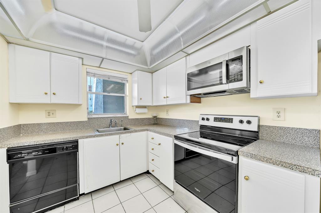 6200 Northwest 44th Street, Unit 405 Lauderhill, FL 33319 - Photo 9 of 44 a kitchen with cabinets stainless steel appliances and a sink