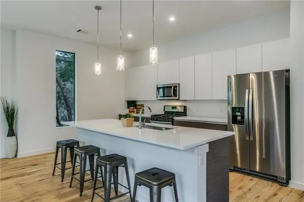 a kitchen with kitchen island appliances cabinets and wooden floor