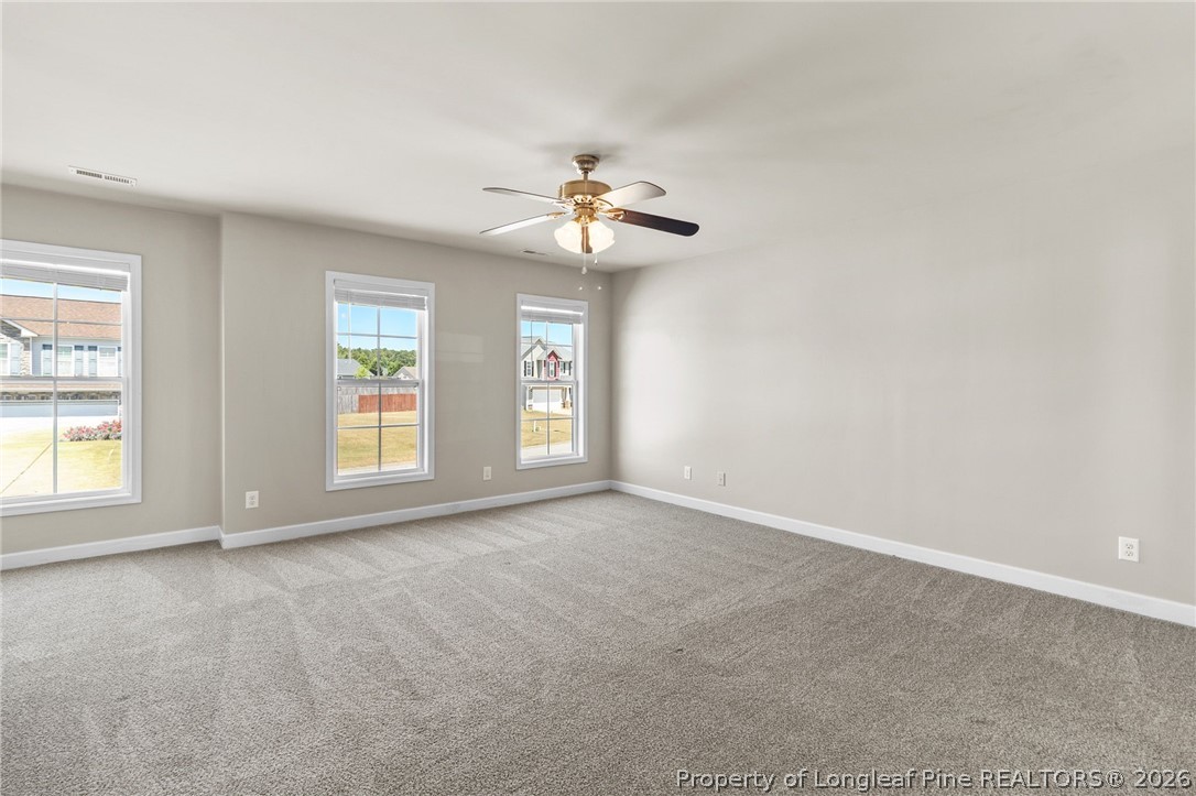 269 Declaration Drive Raeford, NC 28376 - Photo 21 of 44 an empty room with windows and chandelier fan