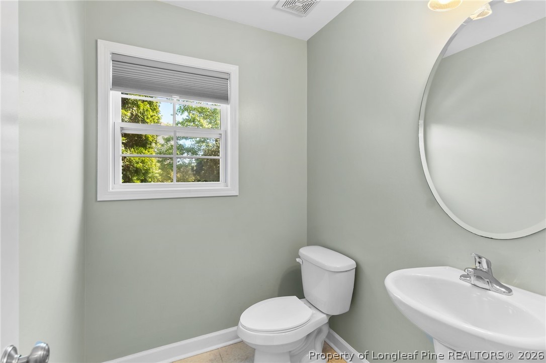 269 Declaration Drive Raeford, NC 28376 - Photo 9 of 44 a bathroom with a toilet a sink and a mirror