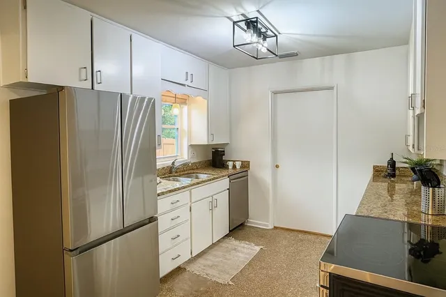 a kitchen with stainless steel appliances a refrigerator and a stove top oven